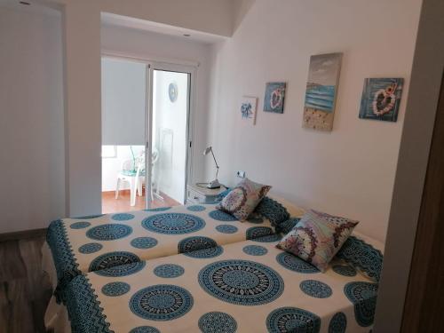 1 dormitorio con 1 cama con edredón azul y blanco en Apartamento en la playa con piscina, en Benalmádena