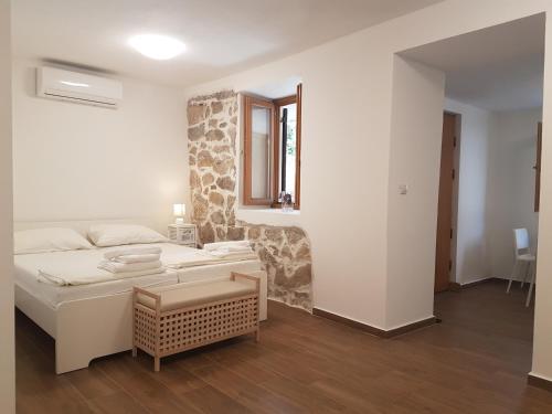 a white room with a bed and a window at Apartments Jungic, Rab in Rab
