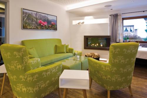 un soggiorno con divano, sedie e camino di Pension Angelika a Pettneu am Arlberg