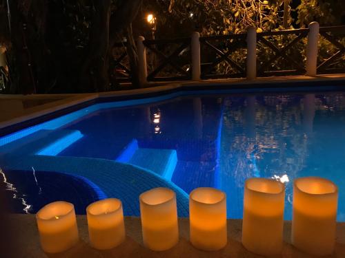 a swimming pool at night with lit candles in it at Hotel Amar Inn in Puerto Morelos