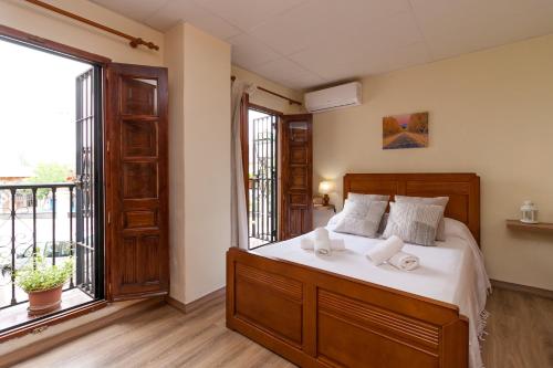 1 dormitorio con cama y ventana grande en Aljibe Albaicín House by A3Rentals, en Granada