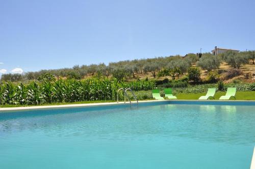 a large swimming pool with chairs at Quinta Rota d' Oliveira in Santa Maria de Émeres