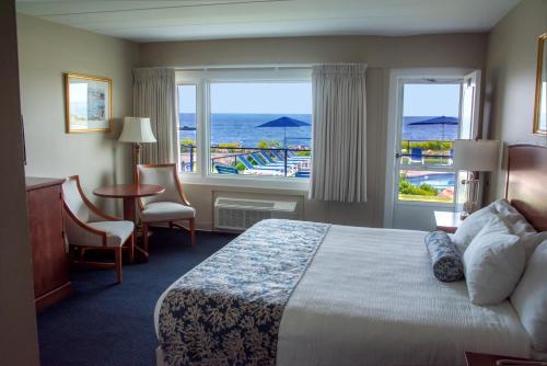 グロスターにあるAtlantis Oceanfront Inn Gloucesterのベッド付きのホテルルームで、海の景色を望めます。