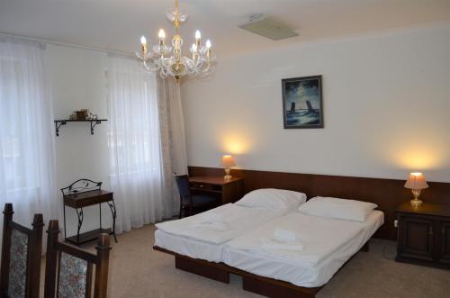 a bedroom with a bed and a chandelier at Hotel Petr in Karlovy Vary