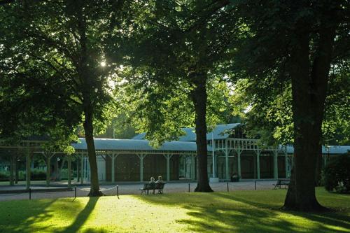 two people sitting on benches in front of a building at Café Mandeltårtan B&B VillaFloraViola in Ronneby