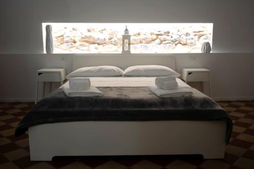 a bedroom with a bed with a large window at Reusuite in Ragusa