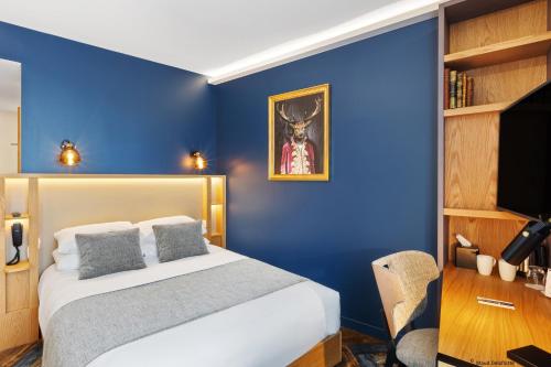 a blue bedroom with a bed and a chair at Aiden by Best Western T'aim Hotel & SPA in Compiègne