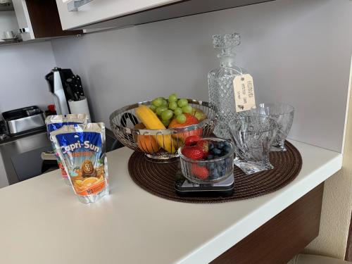 a kitchen counter with bowls of fruit and a bottle at Apartman HIGHTATRAS VIEW Centrum Poprad in Poprad