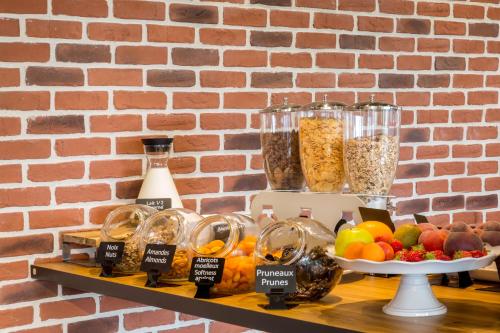 a shelf with a bunch of different types of food at Aiden by Best Western T'aim Hotel & SPA in Compiègne