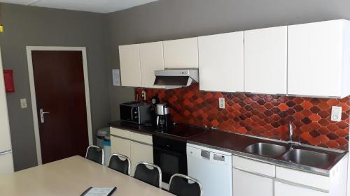 a kitchen with white cabinets and a counter top at Le Moulin Lemaire in Houffalize