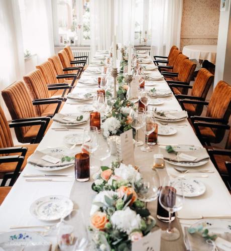 a long table with plates and flowers on it at Hotel de la Gaichel in Eischen