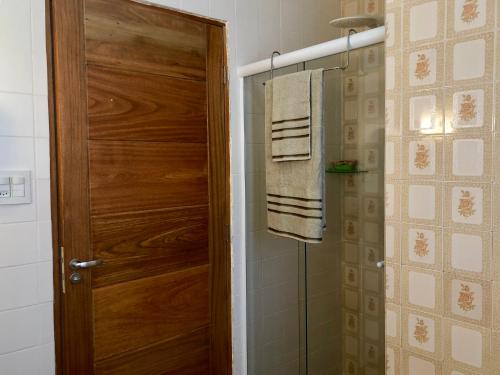 a bathroom with a wooden door and a towel at Pousada Monte Alegre in Sao Paulo