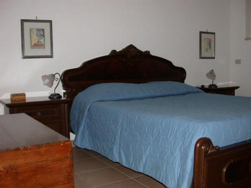 a bedroom with a large bed with a blue blanket at Casa Vacanze Agriturismo BioMele in Policoro