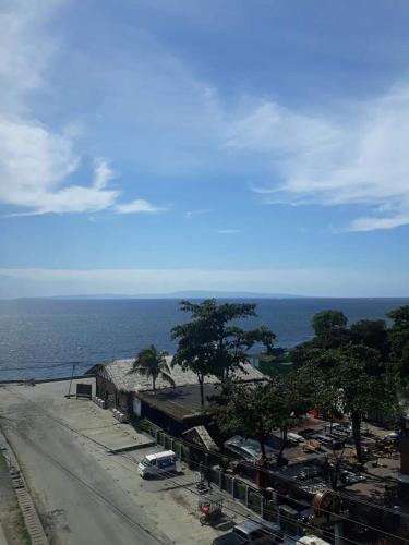 a street with cars parked next to the ocean at B2B Condo, MARINA SPATIAL - Dumaguete in Dumaguete