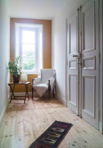 una stanza con una porta, una sedia e una finestra di chambre d'hôte les avettes a Réméréville