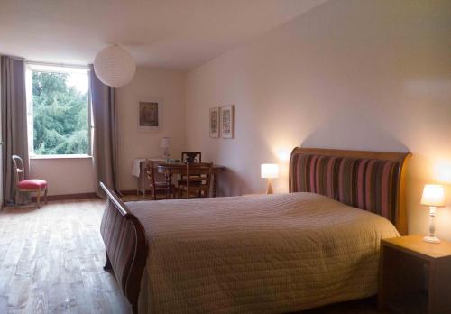 Schlafzimmer mit einem Bett, einem Tisch und einem Fenster in der Unterkunft chambre d'hôte les avettes in Réméréville
