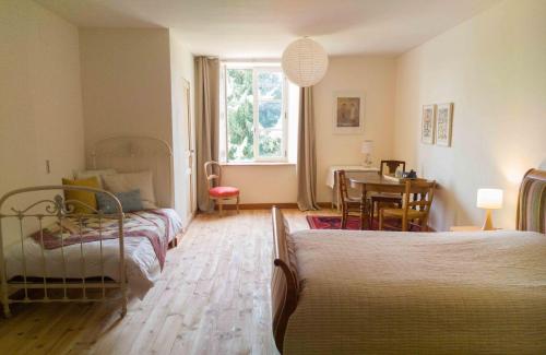 a bedroom with two beds and a dining room with a table at chambre d'hôte les avettes in Réméréville