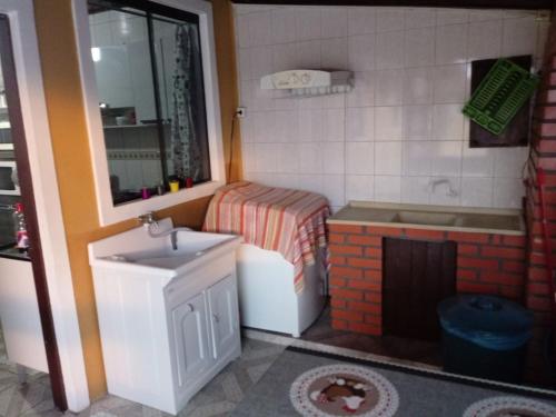 uma casa de banho de brinquedo com um lavatório e uma banheira em Pousada Residencial Caroa em Florianópolis
