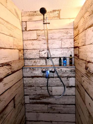 - une douche dans une chambre dotée d'un mur en bois dans l'établissement Appartement du golf, à La Grande Motte