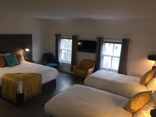 um quarto de hotel com duas camas e uma cadeira em Base Dingle em Dingle