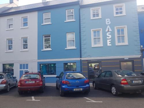 a group of cars parked in front of a blue building at Base Dingle in Dingle