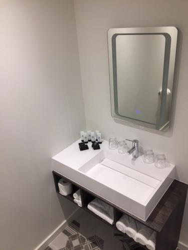 a bathroom with a white sink and a mirror at Base Dingle in Dingle