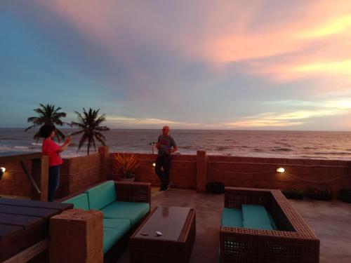 a man and a woman standing on a patio overlooking the ocean at Green Ayurvedic Beach Resort in Negombo