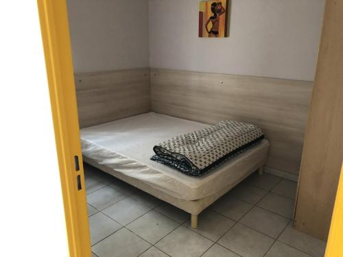 サロン・ド・プロヴァンスにあるAppart Hotel Acadienの小さな客室で、小さなベッドが備わります。