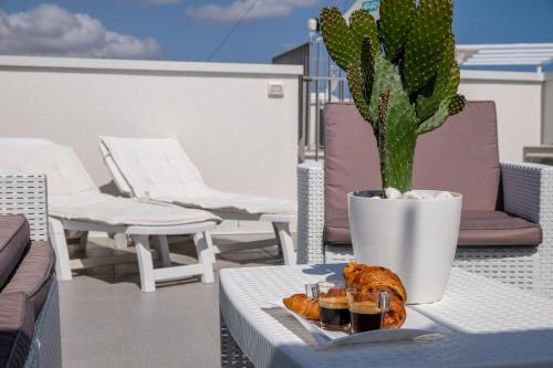 une table avec une plaque de nourriture et une plante dans l'établissement Dimora Punta Azzurra, à Polignano a Mare