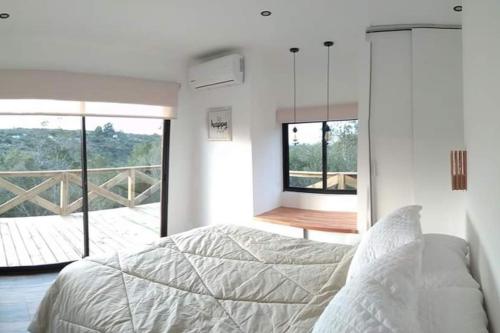 a bedroom with a bed and a view of a balcony at Villa Serrana Relax & Confort in Villa Serrana