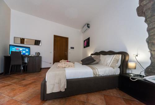 a bedroom with a bed and a desk and a television at Le Undici Rose Hotel in Viterbo