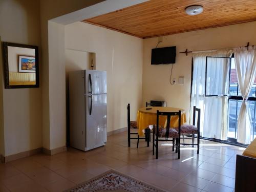 Il comprend une cuisine et une salle à manger avec une table et un réfrigérateur. dans l'établissement Anto Jujuy, à San Salvador de Jujuy