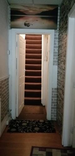 un couloir avec une porte blanche et un escalier dans l'établissement Carib Inn, à Manchester