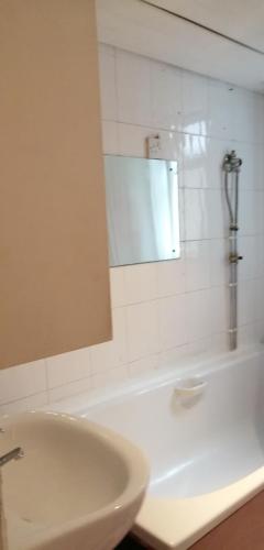a bathroom with a sink and a mirror and a tub at Carib Inn in Manchester