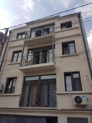 Un grand bâtiment avec des fenêtres et un balcon est disponible. dans l'établissement Tbilisi Center Hotel, à Tbilissi