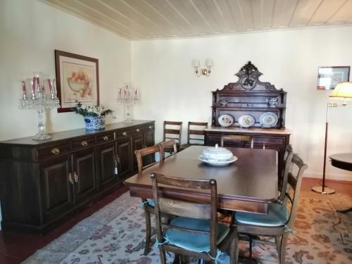 uma sala de jantar com uma mesa de madeira e cadeiras em Douro Valley - Casa da Praça em Ervedosa do Douro