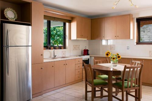 a kitchen with a table and chairs and a refrigerator at Apartment in Peania (15min from Airport) in Paianía