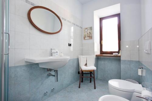 a bathroom with a sink and a toilet and a mirror at La Coccinella B&B in Boves