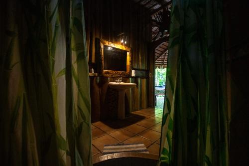 uma casa de banho com uma cortina de chuveiro e um lavatório em Hotel La Costa de Papito em Puerto Viejo