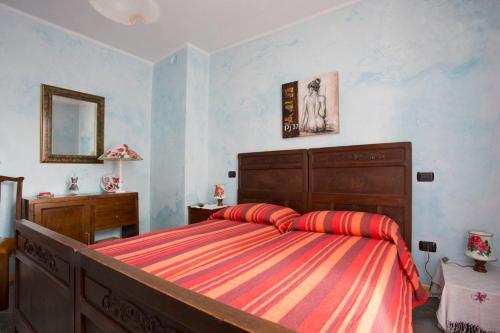 una camera con un letto con una coperta a righe rosse e arancioni di La Coccinella B&B a Boves