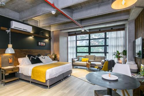 a bedroom with a bed and a living room at Factory Lofts Hotel in Medellín
