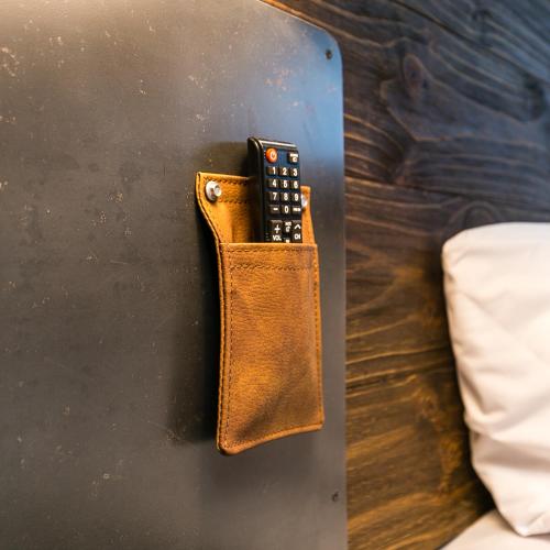 a remote control in a wallet hanging on a wall at Factory Lofts Hotel in Medellín