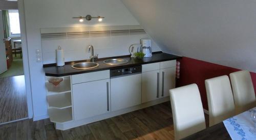 a kitchen with two sinks and a red wall at Ferienwohnung Lehnert in Radeberg