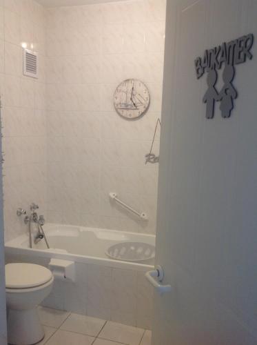 Un baño con inodoro, bañera y lavabo. en Beach front property, en Strand