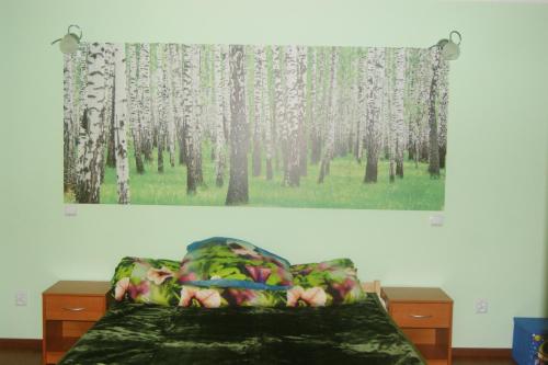 a painting of trees on the wall above a bed at Waszczyszynówka Bieszczady in Bandrów Narodowy