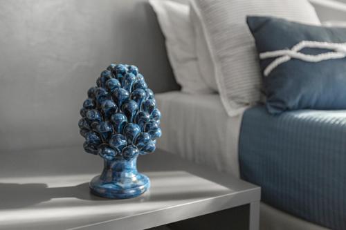 a blue vase on a table next to a couch at B&B Dimora dei Templi in Agrigento
