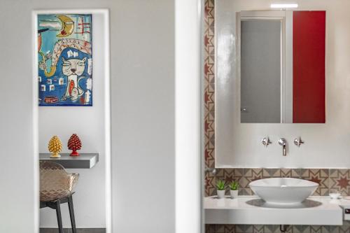 ein Bad mit einem Waschbecken und einem Spiegel in der Unterkunft B&B Dimora dei Templi in Agrigento