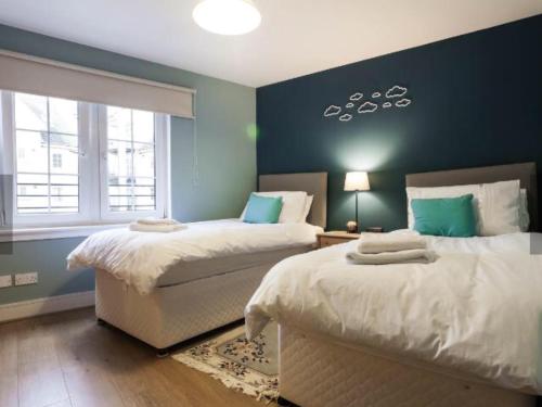 Un dormitorio con dos camas y una pared azul. en 20/5 Timber Bush, en Edimburgo