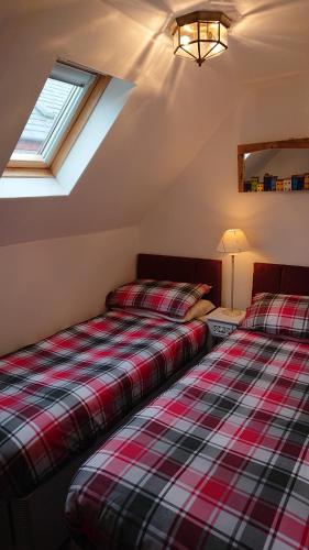 two beds sitting next to each other in a room at Seaforth Cottage. in Nairn