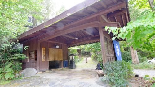 a wooden building with a pavilion in a park at Yumoto Choza in Takayama